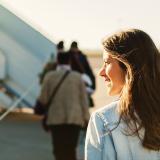 Woman boarding airplane with sunlight in the background